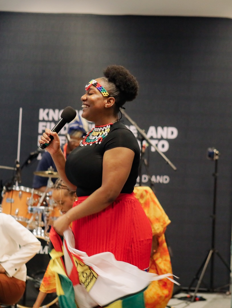 A woman singing in front of the worship band
