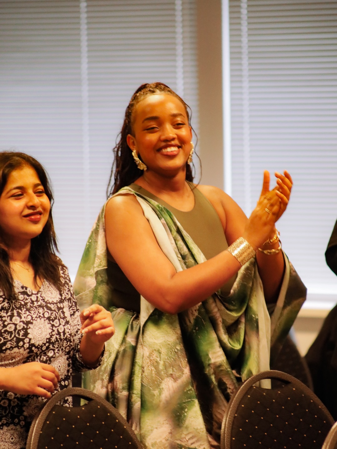 Two women clapping during the gathering