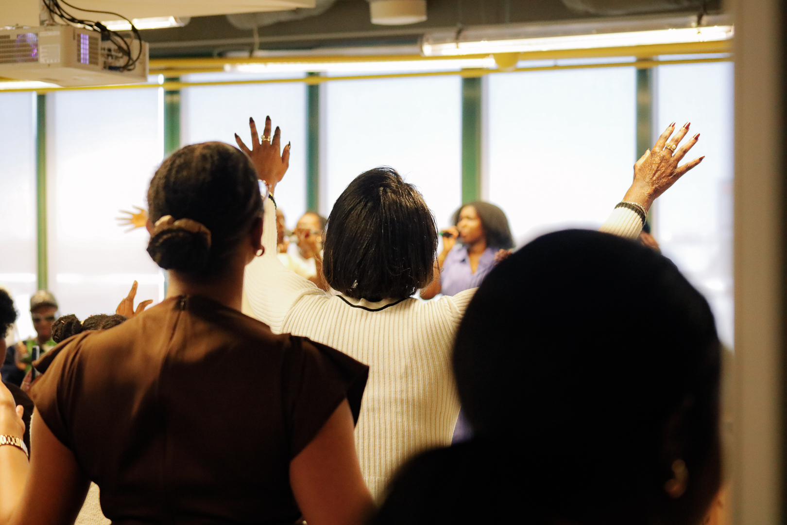 The congregation worshiping with hands raised